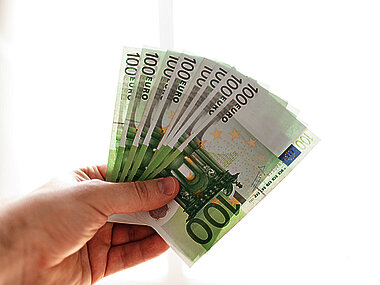 Hand mit mehreren 100 Euro-Scheinen